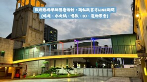 A modern pedestrian bridge with a glass walkway and colorful lighting. - I live Motel (Kaohsiung)