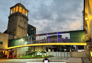 A hotel entrance with a modern bridge, a clock tower, and a registration sign. - I live Motel (Kaohsiung)