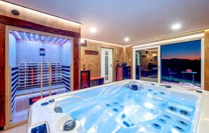 Relax in a serene spa room with a hot tub, sauna, and outdoor views.