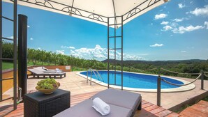 Area piscina con lettini e vista sul paesaggio.