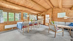 Puinen mökki, jonka sisätiloissa on ruokailutila, keittiö ja oleskelualue.