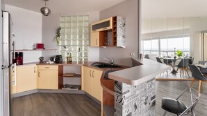Una cocina moderna con isla integrada, zona de comedor con vistas y un ventanal grande.
