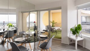 Un comedor moderno con una mesa de vidrio, sillas y un balcón con vistas.