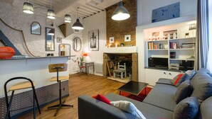 A modern living room with a fireplace, bookshelves, and a dining area. - COCON URBAIN Centre Historique (Rennes)