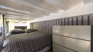 A bedroom with a bed, a white headboard, and a patterned wall. - COCON URBAIN Centre Historique (Rennes)