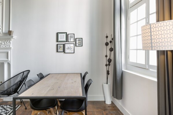 A dining area with a wooden table, black chairs, and framed inspirational quotes on the wall.