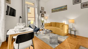 Una sala moderna con un sofá, una mesa de comedor y una mesa auxiliar.