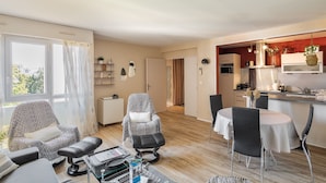 Un espace de vie compact comprenant un coin repas, une kitchenette et une vue par la fenêtre.