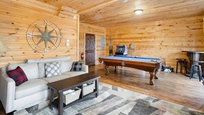 A cozy room with a pool table, a large compass wall decoration, a sofa, and a coffee table. - Walk to Beech Mtn Resort, Sleeps 12, Game Room (Beech Mountain)