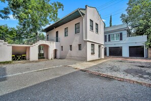A two-story building with a flat roof, a covered entrance, and a small patio area with outdoor seating.
