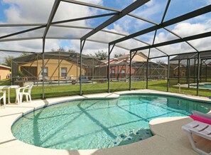A swimming pool with a covered area, surrounded by houses and a grassy yard. - Villa Alexa (Davenport)