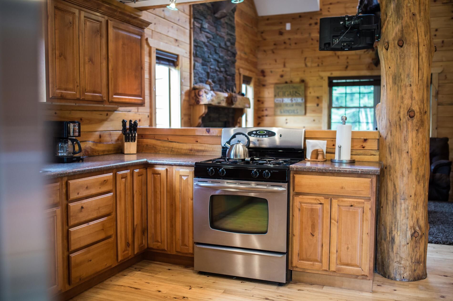A kitchen with wooden cabinets, a stainless steel stove, and a coffee maker.