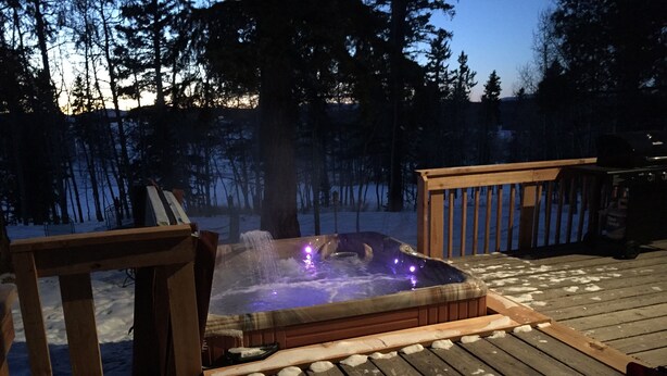 A hot tub on a wooden deck with snow on the ground. - Romantic Forest Hideaway, Hot Tub, WiFi, near Attractions & Breweries!  (Divide)