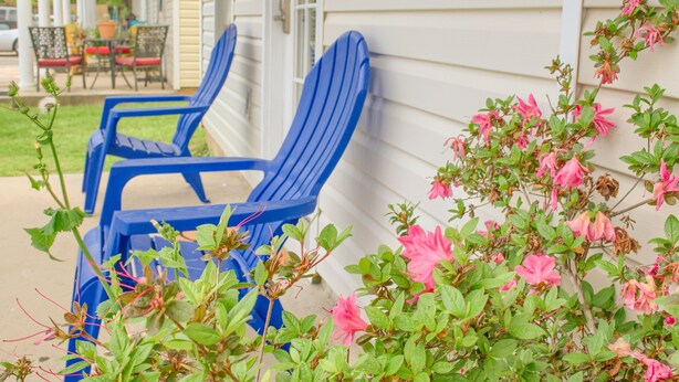 Two blue Adirondack chairs outside a house with a porch, pink flowers, and a green plant. - 5 min walk to BEACH (1 block). Newly RENOVATED Spacious 3Beds 3Baths (Gulfport)