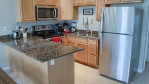A modern kitchen with wooden cabinets, stainless steel appliances, and a granite countertop. - 5 min walk to BEACH (1 block). Newly RENOVATED Spacious 3Beds 3Baths (Gulfport)