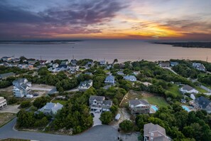 An aerial view of a residential area with houses, roads, and a large body of water. - Cozy Appartment: Hottub, Kayak, SUPs, and Bikes. Dogs or cats ✅  (Kitty Hawk)