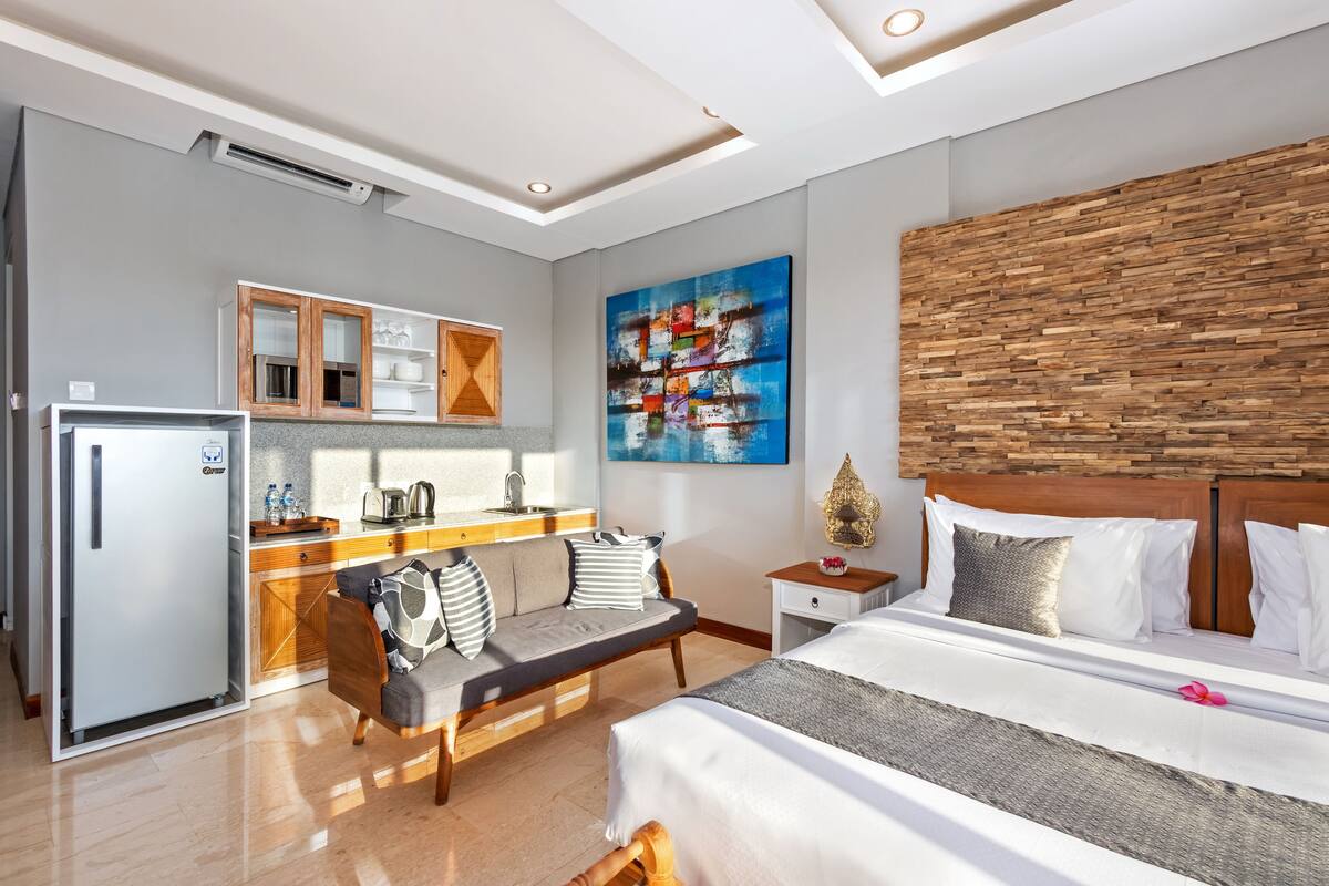 Una habitación de hotel moderna con cama, sofá, comedor y cocina.
