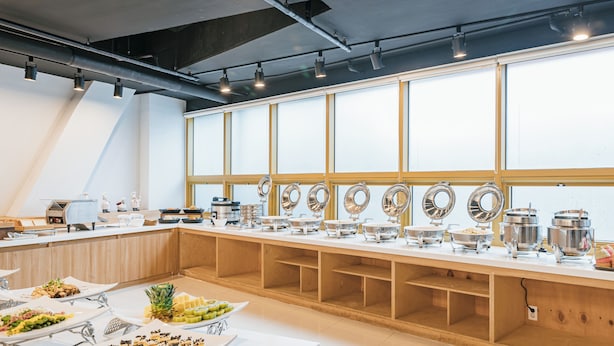Un buffet avec différents postes de service et des ustensiles pour se servir.