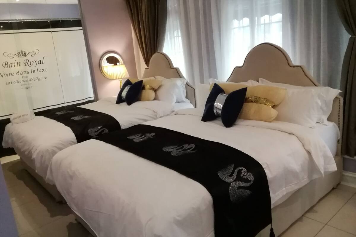 A hotel room with two beds, a large mirror, and a view of the city.