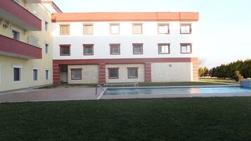 A multi-story building with a swimming pool in the foreground.