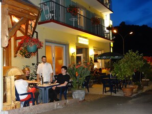 Ein Restaurant im Freien mit Tischen, Stühlen und Blumentöpfen.