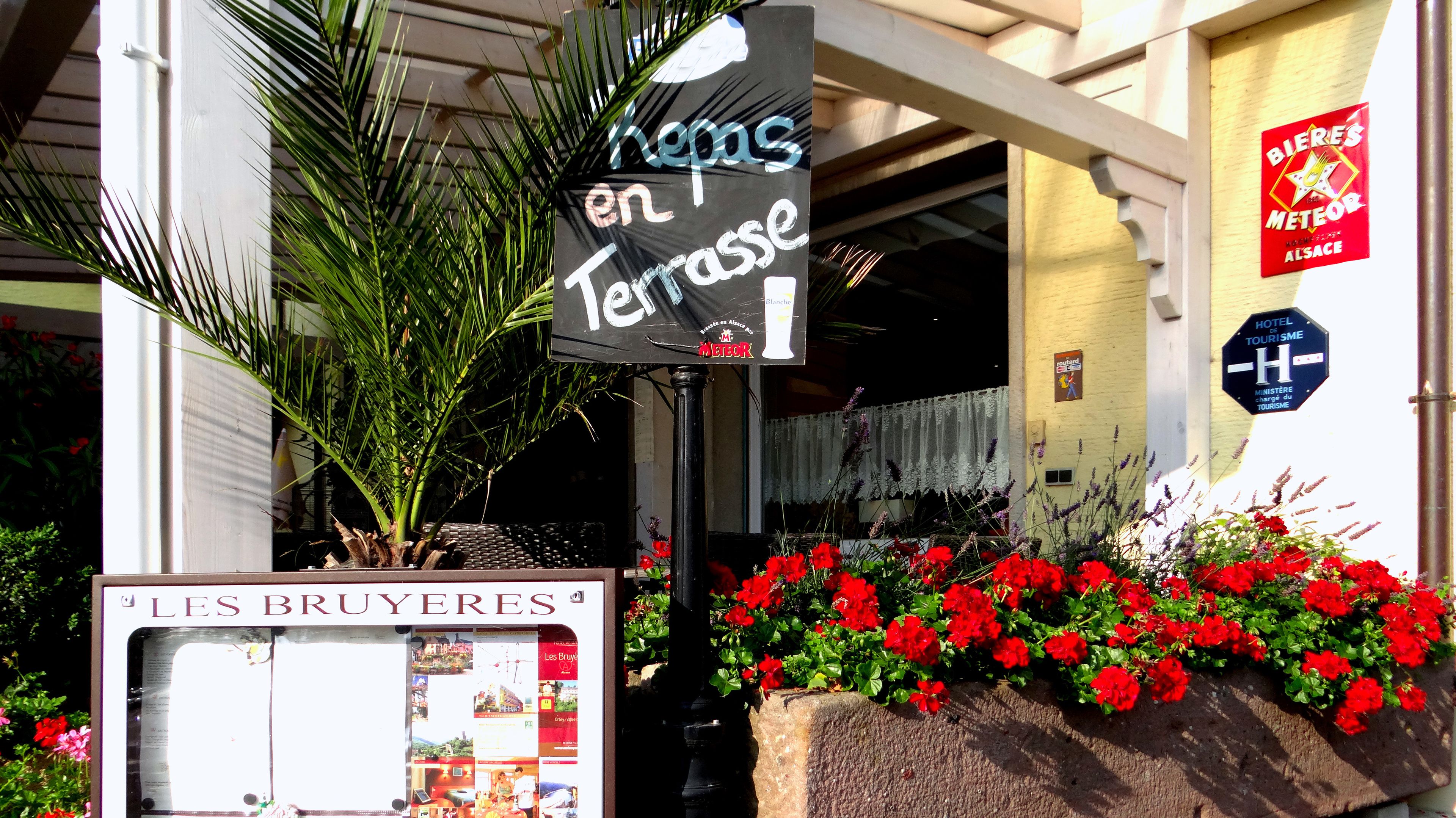 A hotel entrance with a sign reading "Les Bruyères en Terrasse" and a sign for "Bieri's Meteor".