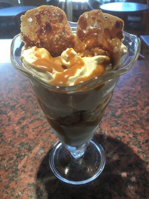 Dessert in einer Glaskugel mit Karamellsauce und Karamellüberzug.