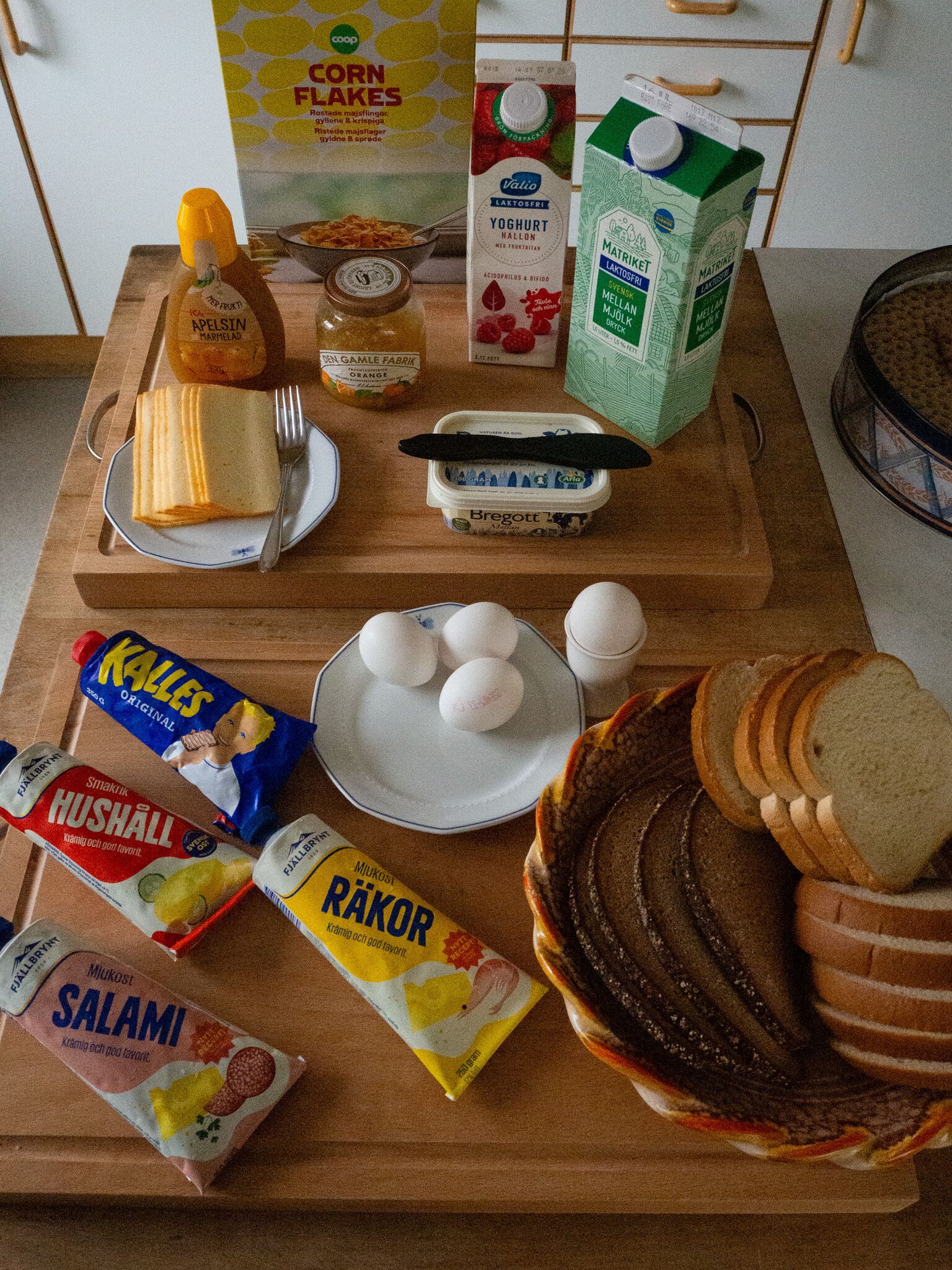 Una encimera de cocina con diversos alimentos e ingredientes, como pan, huevos y salsas.