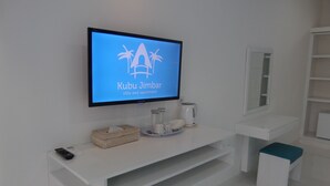 Un baño moderno con un televisor montado que muestra 'Kubu Jimbar villa and apartment'.