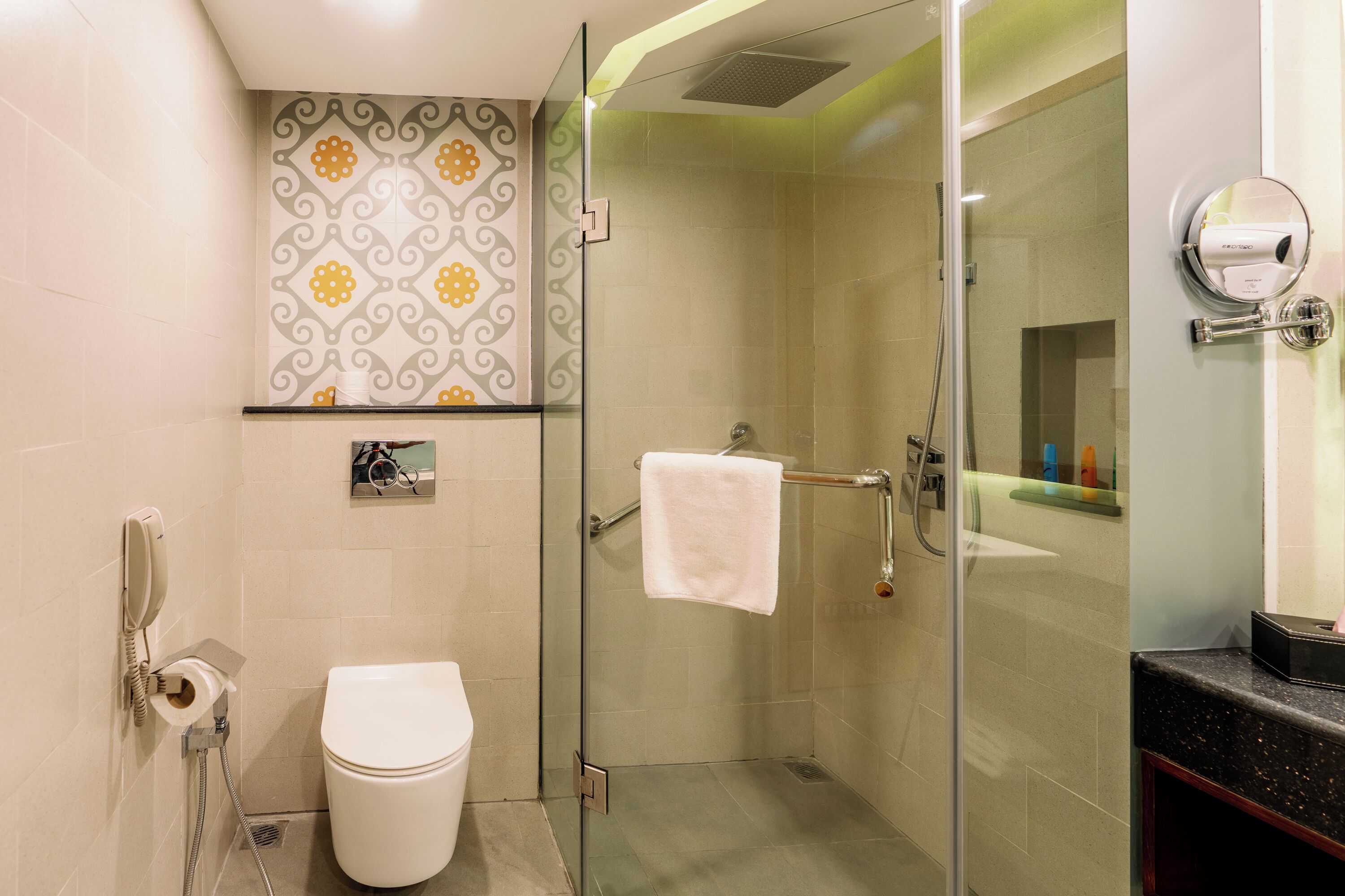 A bathroom with a glass shower enclosure, a toilet, a towel rack, and a mirror.