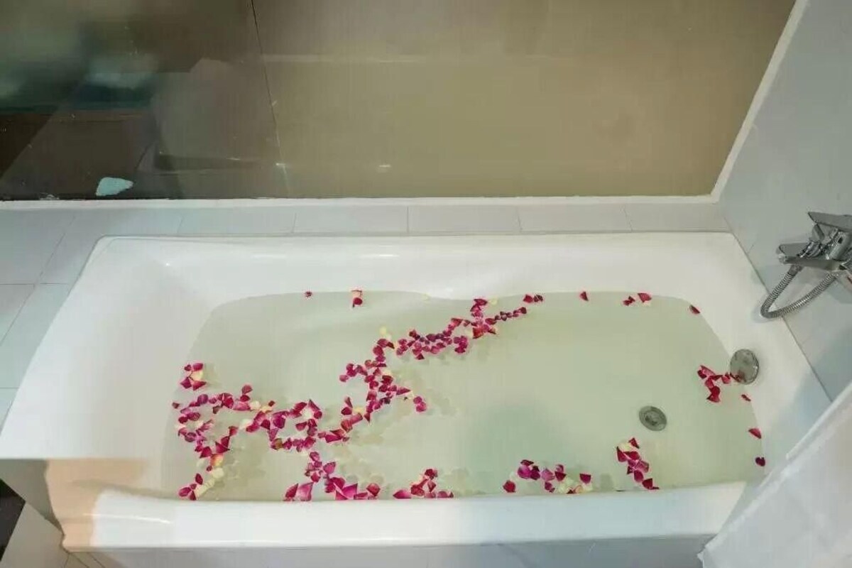 Een bad vol water en rozenblaadjes.