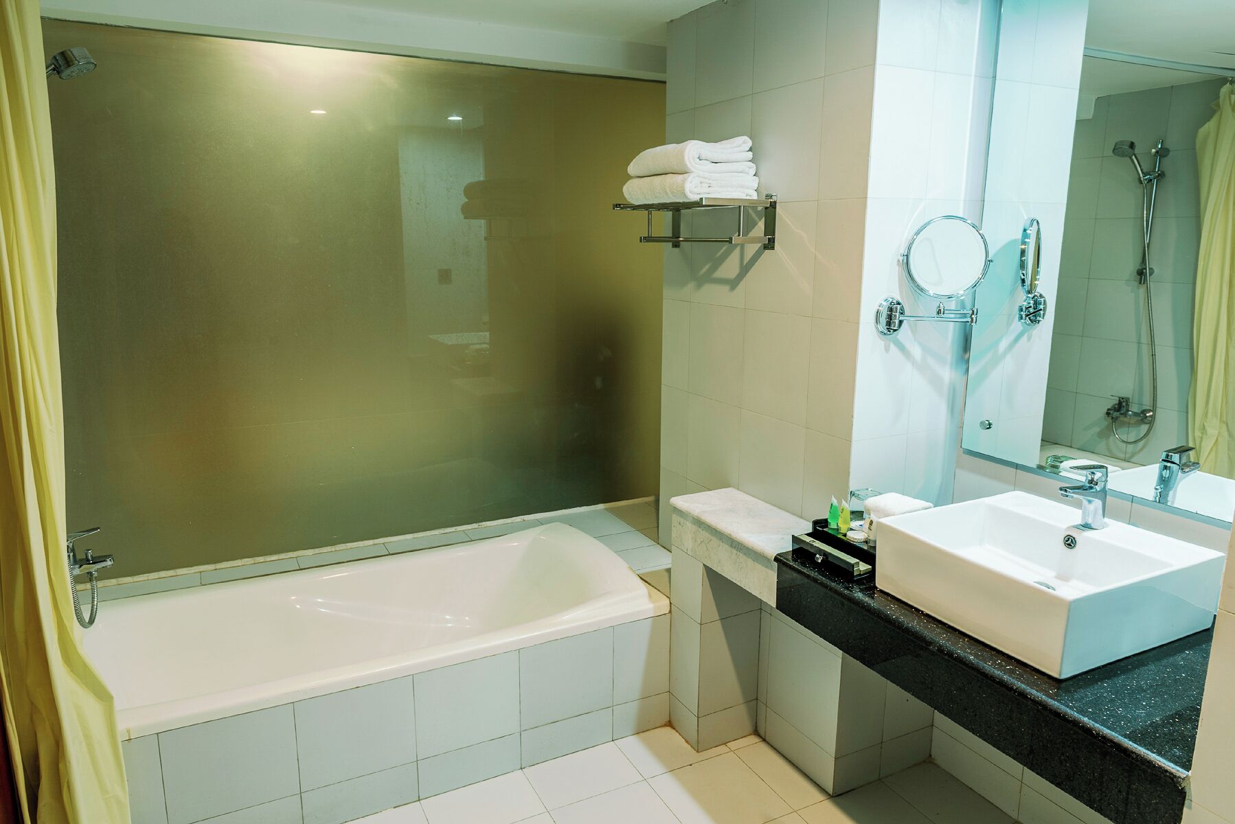 Une salle de bain moderne avec une baignoire, un meuble-lavabo avec un miroir et un espace douche.