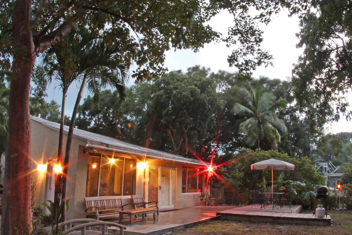 A house with a porch, outdoor seating, and a small garden area.