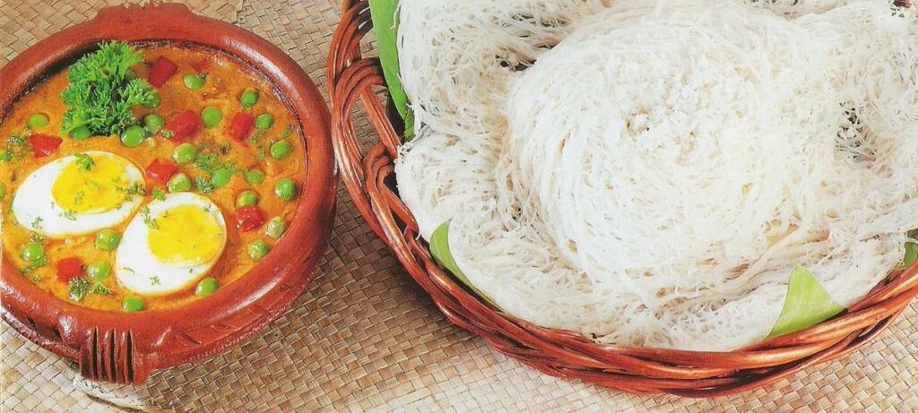 A clay pot with a stew and sliced boiled eggs, and a woven basket with white noodles.