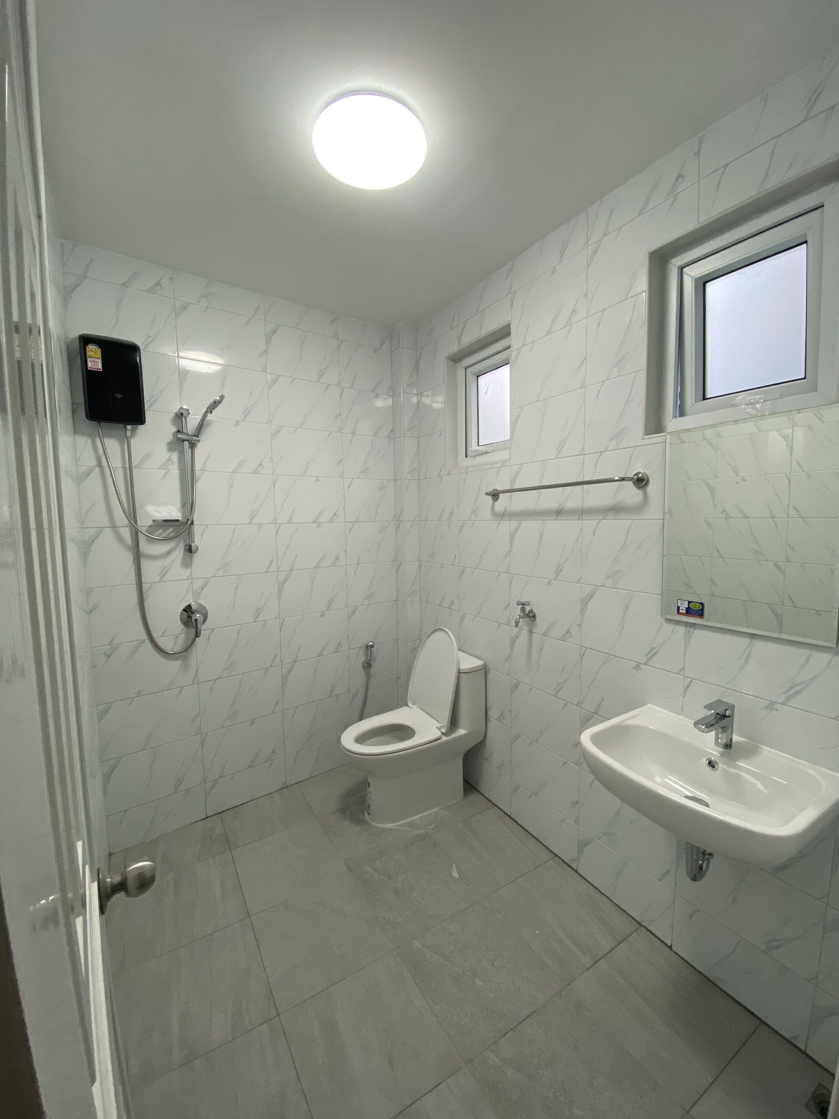 A bathroom with a toilet, a sink, and a shower.
