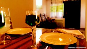 A dining table with plates, a wine glass, and cutlery. - Sana Guest (Weligama)