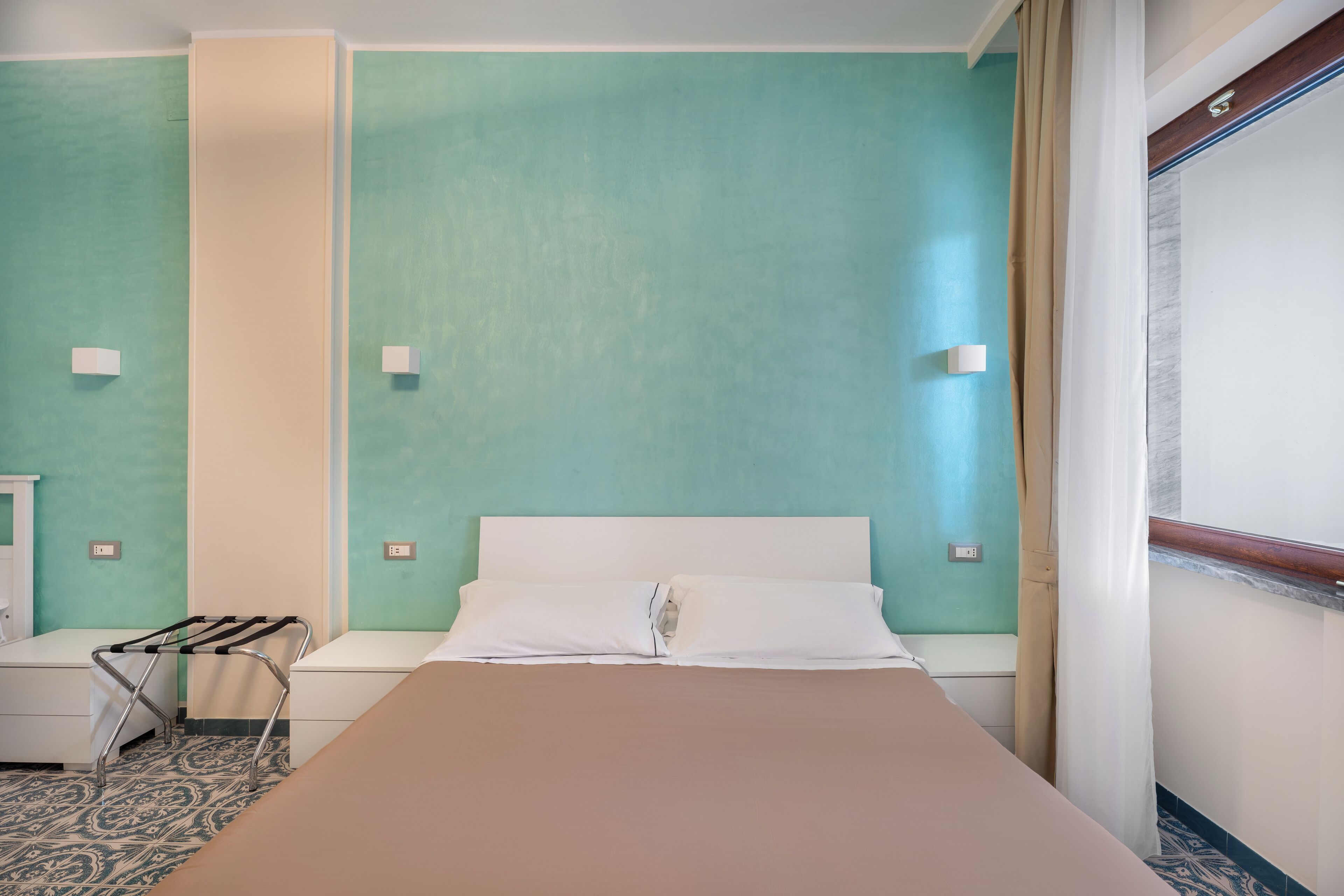 Una habitación de hotel con una cama, una mesita y una silla.