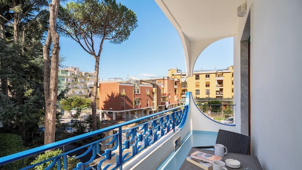Un balcón con vistas a edificios y árboles.