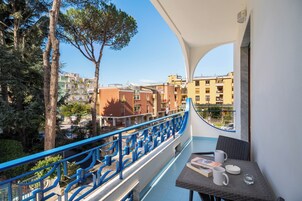 Un balcone con vista su edifici e alberi.