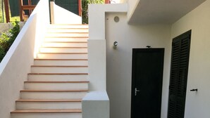 A staircase leading to a door with a vent and a light fixture above it. - La Bouganville (Vibonati)