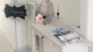 A bathroom vanity with a large mirror, a decorative birdcage, and a sign with the text "da bouguamville". - La Bouganville (Vibonati)