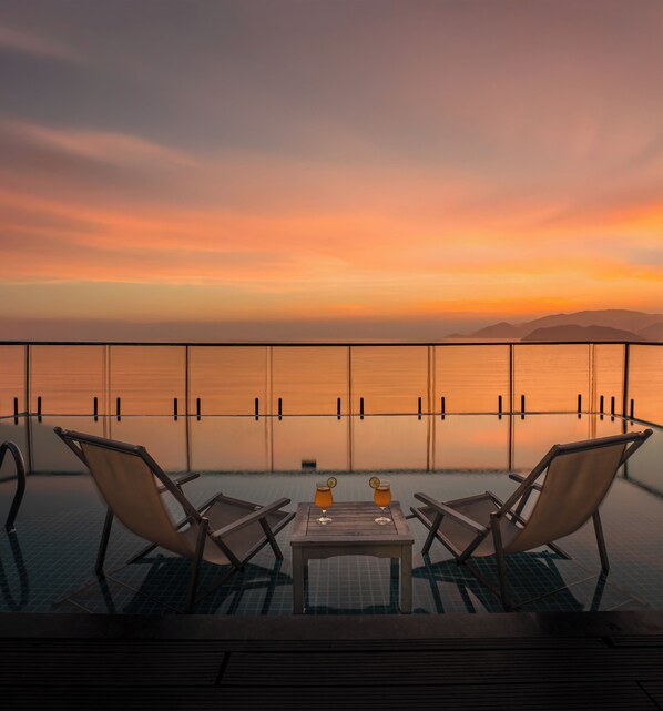 Alberca al aire libre, sombrillas en la alberca y camastros