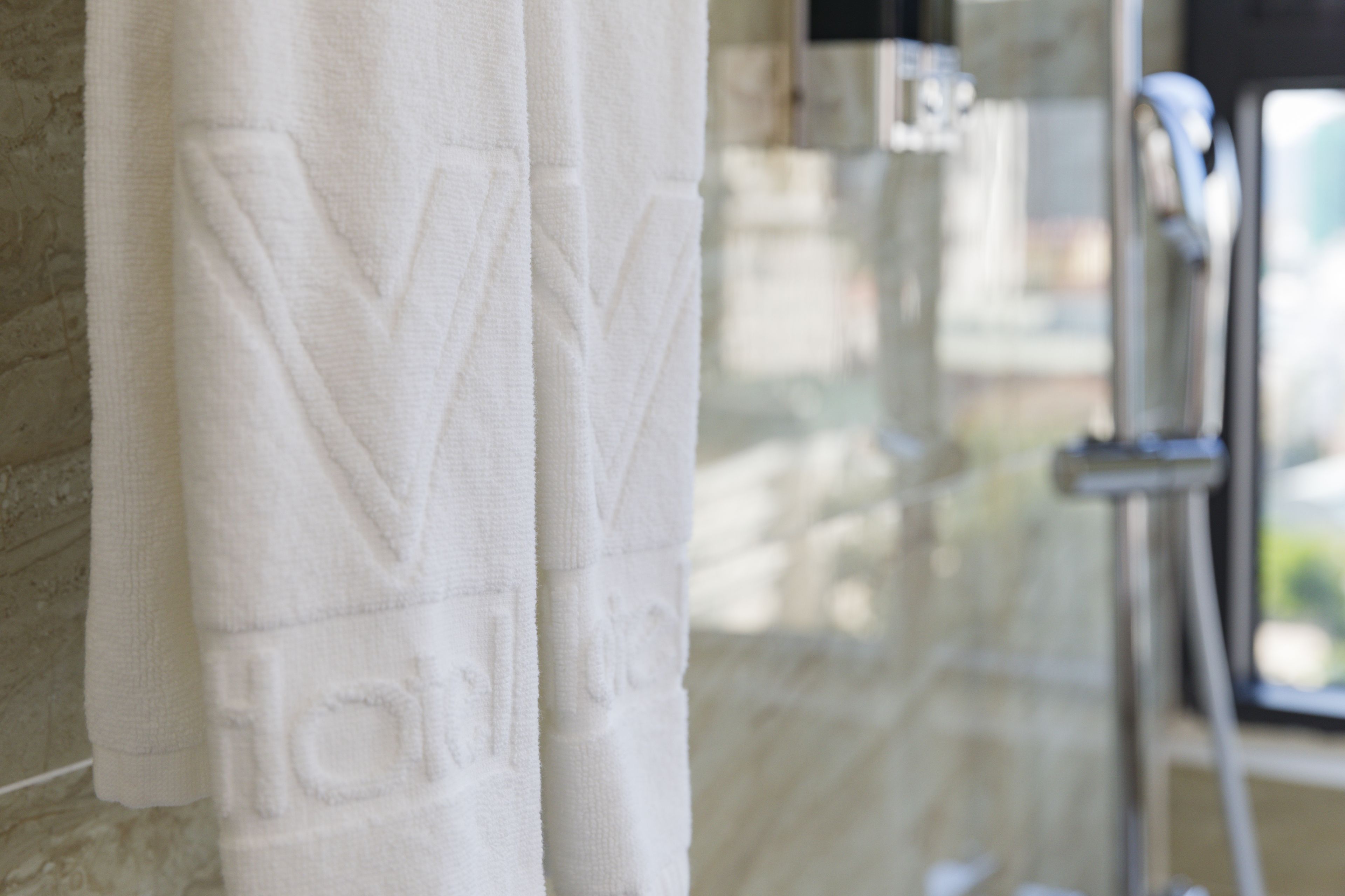 Toalla blanca con texto en relieve colgada en una pared.