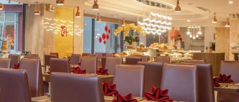 A restaurant interior with booths and tables, ceiling fans, and decorative lighting.