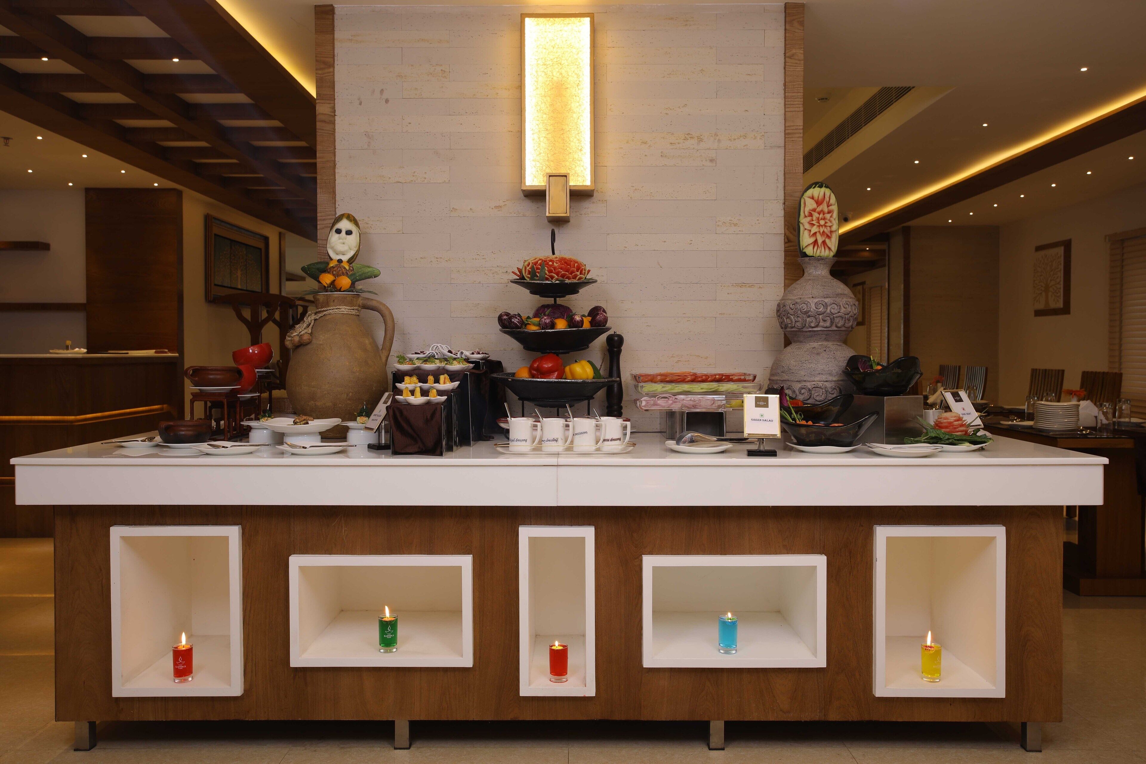 A reception area with a counter, a vase, a fruit bowl, and a wall-mounted light fixture.