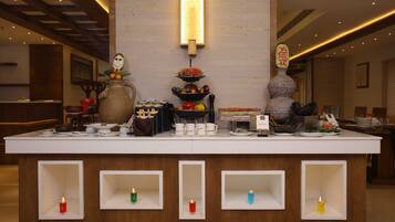 A reception area with a counter, a vase, a fruit bowl, and a wall-mounted light fixture.
