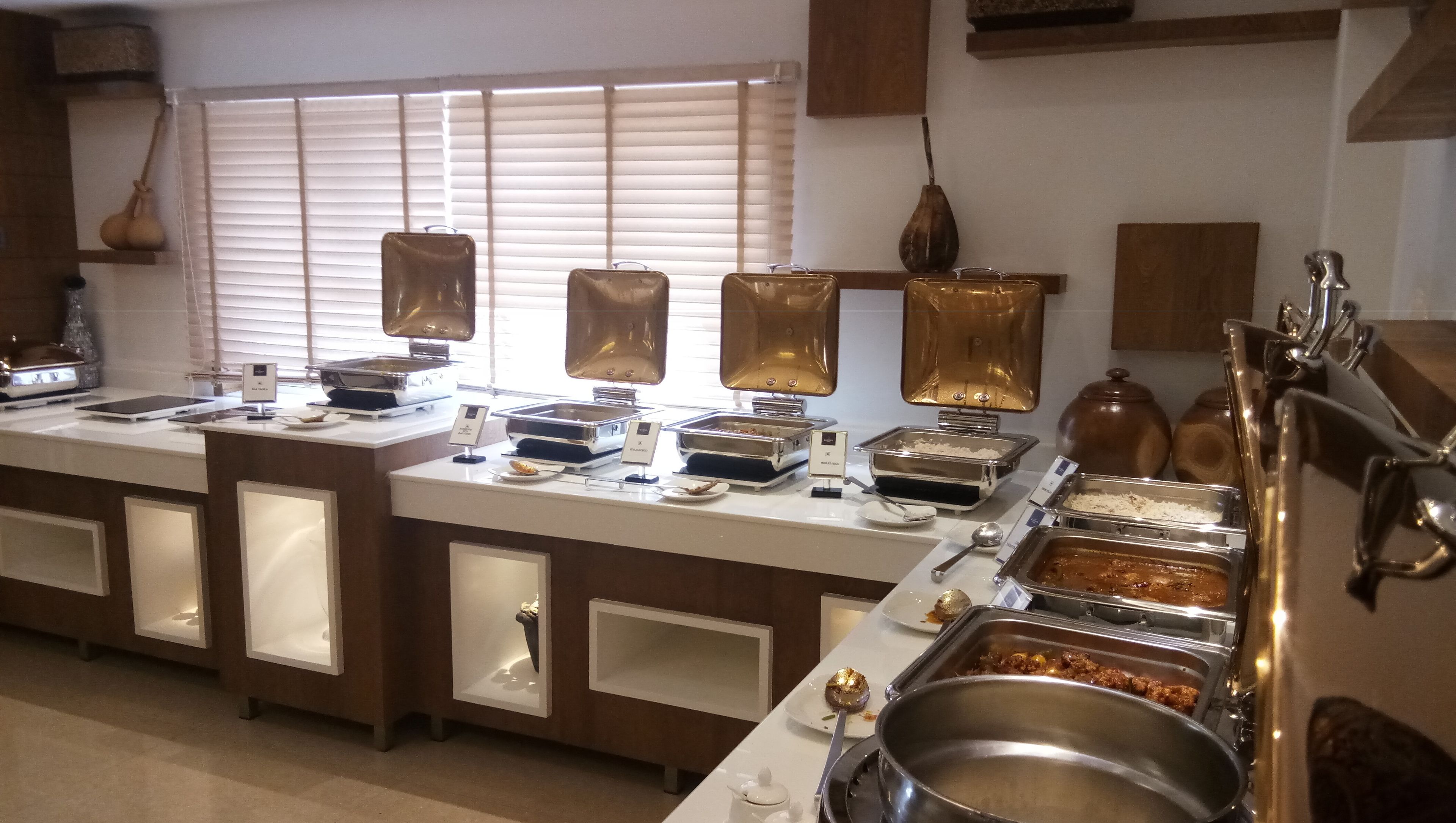 A buffet setup with various food stations, including a meat station and a dessert station.