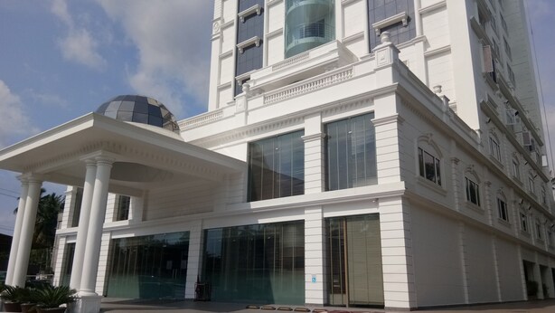Un edificio blanco con ventanas grandes y un porche cubierto.