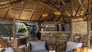 Un espace extérieur aménagé dans un style rustique, avec des meubles en bois et un bar en pierre.