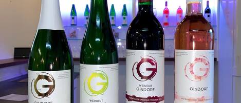 Cuatro botellas de vino con etiquetas sobre una superficie de madera.